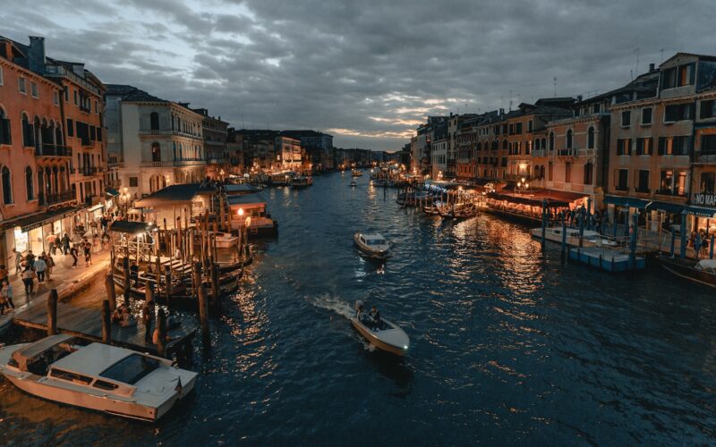 white and blue boat on water near buildings during daytime